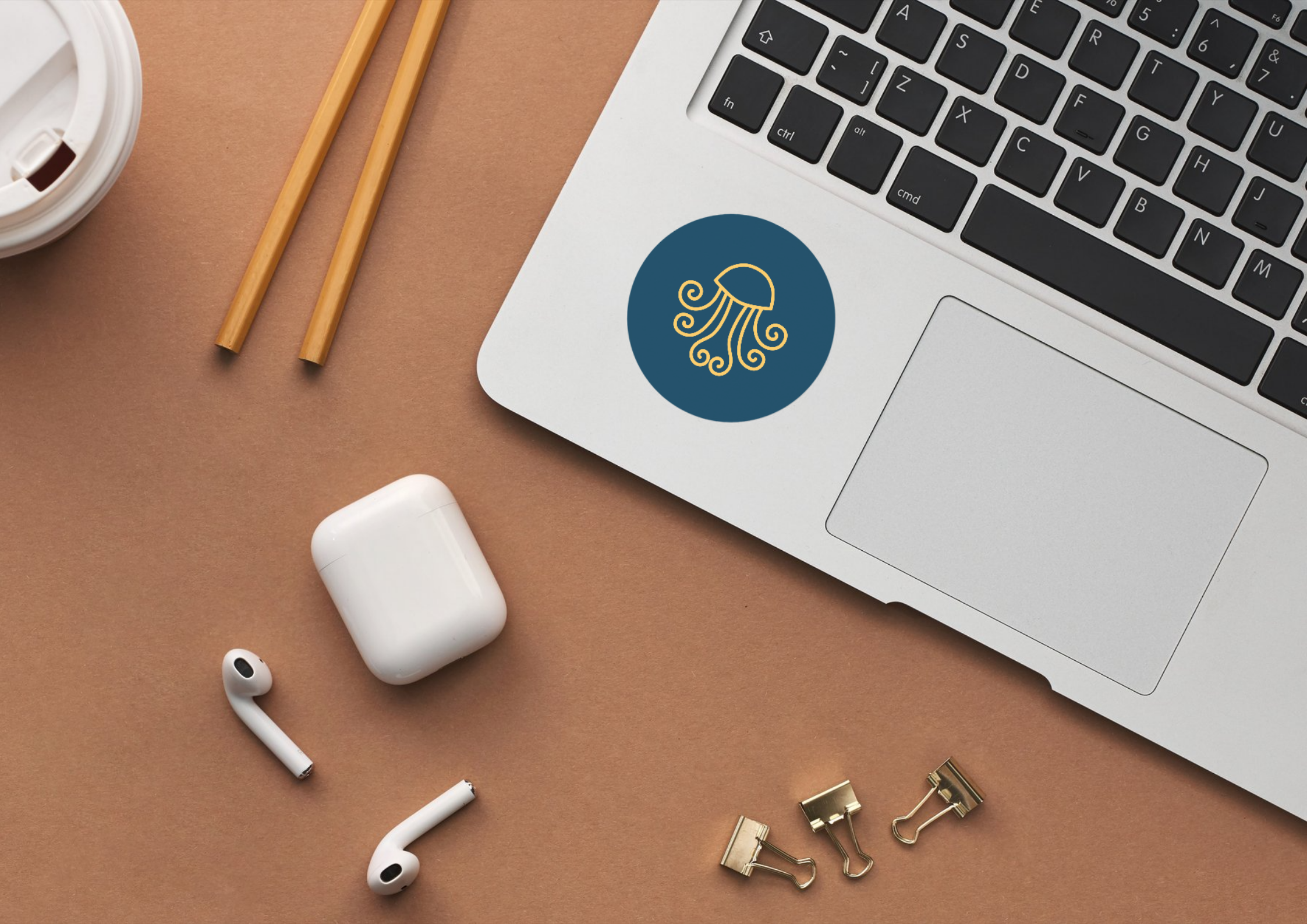 A sticker with just the MeloJelly's icon on a laptop, viewed from above.